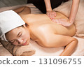 A young Asian woman is getting a back oil massage. 131096755