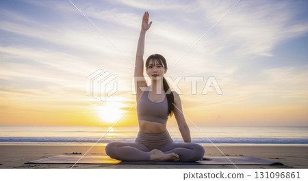 Woman doing yoga exercises on the beach at sunrise Woman doing yoga exercises on the beach at sunrise 131096861