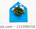white flower jasmine on blue envelope arrangement flat lay postcard style 131098258