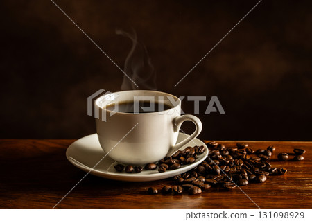 Hot coffee and coffee beans on the table 131098929