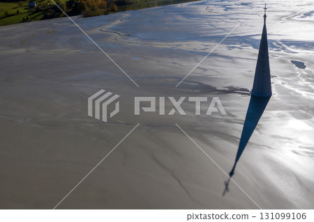 Abstract aerial view of silhouette of church tower with cross and shadow, flooded by copper mining residuals and mud 131099106