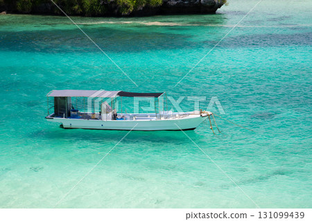 Ishigaki Island: A small white boat floating in the emerald green Kabira Bay Ishigaki Island: A small white boat floating in the emerald green Kabira Bay 131099439