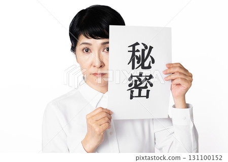 A senior woman with a serious look on her face holding a piece of paper with the word "secret" written on it A senior woman with a serious look on her face holding a piece of paper with the word "secret" written on it 131100152