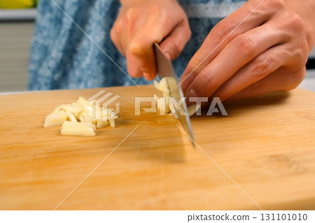 Chef woman hands cooking chopping cutting garlic on wooden board on kitchen. Chef woman hands cooking chopping cutting garlic on wooden board on kitchen. 131101010