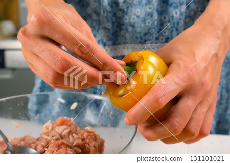 Woman hands are filling bell pepper with minced meat rice cooking on kitchen. Woman hands are filling bell pepper with minced meat rice cooking on kitchen. 131101021