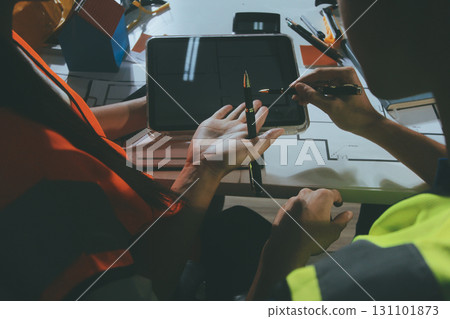 Closeup of team of industrial engineers meeting analyze machinery blueprints consult project on table in manufacturing factory. Working in manufacturing plant or production plant. 131101873