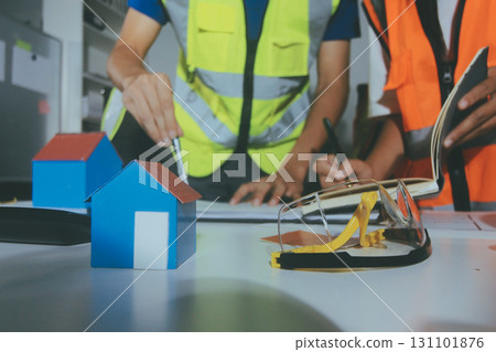 Closeup of team of industrial engineers meeting analyze machinery blueprints consult project on table in manufacturing factory. Working in manufacturing plant or production plant. Closeup of team of industrial engineers meeting analyze machinery blueprints consult project on table in manufacturing factory. Working in manufacturing plant or production plant. 131101876