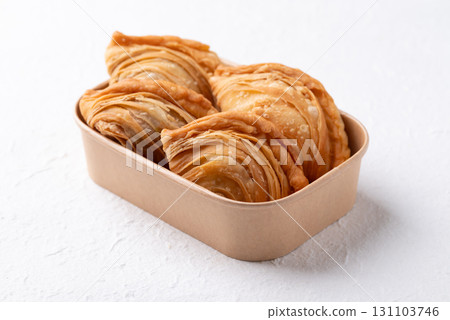 Curry puff stuffed with chicken or sweet potatoes in paper food box on white background Curry puff stuffed with chicken or sweet potatoes in paper food box on white background 131103746