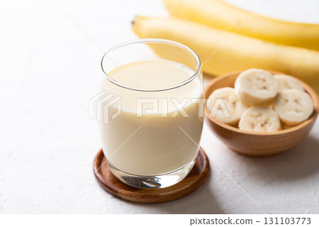 Banana milk in glass with sliced banana and fruit on white background 131103773