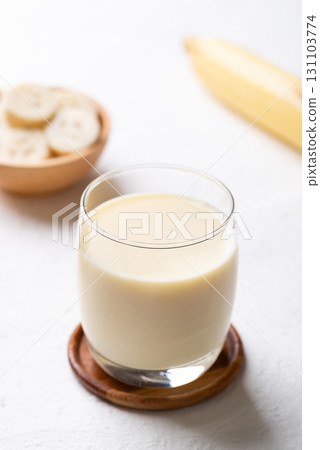Banana milk in glass with sliced banana and fruit on white background 131103774