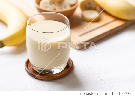 Banana milk in glass with sliced banana and fruit on white background 131103775