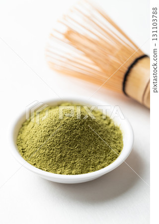 Matcha green tea powder in bowl and bamboo whisk on white background Matcha green tea powder in bowl and bamboo whisk on white background 131103788
