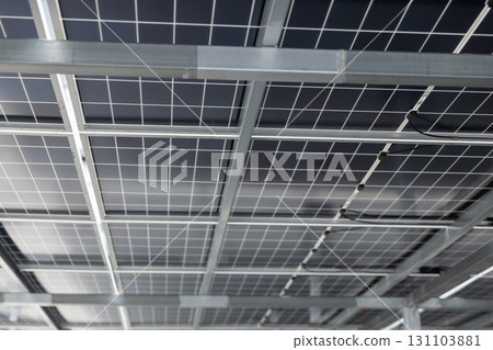 Close-up view of solar panel structure and wiring from underneath. Concept of clean energy, photovoltaic system, renewable power technology, and sustainable infrastructure design. Close-up view of solar panel structure and wiring from underneath. Concept of clean energy, photovoltaic system, renewable power technology, and sustainable infrastructure design. 131103881