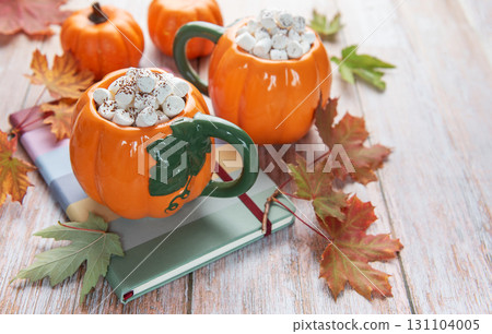 Pumpkin mugs with hot chocolate and marshmallows, autumn concept Pumpkin mugs with hot chocolate and marshmallows, autumn concept 131104005