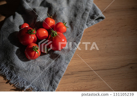Vibrant and Fresh Red, Juicy Tomatoes Delightfully Positioned on a Charming Blue Cloth Background 131105239