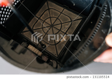 Repair technician male troubleshooting air humidifier, focusing on precision work and professional maintenance of home electronic device. Concept of hygiene and cleanliness in domestic environment. Repair technician male troubleshooting air humidifier, focusing on precision work and professional maintenance of home electronic device. Concept of hygiene and cleanliness in domestic environment. 131105514