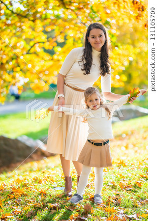 Mother and daughter spending quality time together in autumn park surrounded by colorful trees and fallen leaves, joyful moment of bonding and love in nature Mother and daughter spending quality time together in autumn park surrounded by colorful trees and fallen leaves, joyful moment of bonding and love in nature 131105709