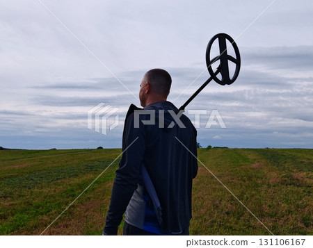 man in a field with a metal detector. Metal detector in action, Treasure hunt. man in a field with a metal detector. Metal detector in action, Treasure hunt. 131106167