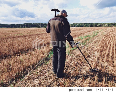 man in a field with a metal detector. Metal detector in action, Treasure hunt. man in a field with a metal detector. Metal detector in action, Treasure hunt. 131106171