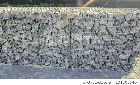 Stone fence construction. Mesh base with stones inside. Open space design 131106540