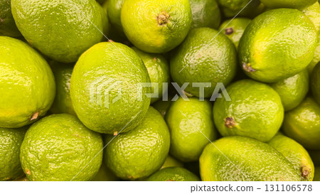 Green limes in large crates on store shelves. Display and sale of citrus fruits. 131106578