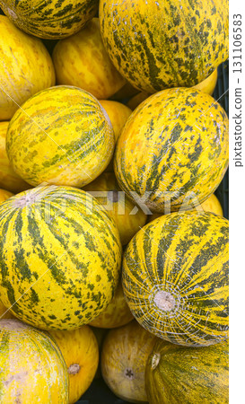 Round yellow melons in large crates on store shelves. Fruit display and sale. Round yellow melons in large crates on store shelves. Fruit display and sale. 131106583