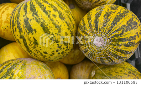 Round yellow melons in large crates on store shelves. Fruit display and sale. Round yellow melons in large crates on store shelves. Fruit display and sale. 131106585