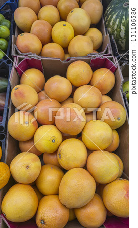 Orange grapefruits in large crates on store shelves. Display and sale of citrus fruits. Orange grapefruits in large crates on store shelves. Display and sale of citrus fruits. 131106586