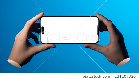Lodz Poland May 01 2025 Hands holding smartphone in horizontal position. Blank screen mockup placed Lodz Poland May 01 2025 Hands holding smartphone in horizontal position. Blank screen mockup placed 131107326