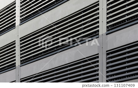 Ventilation facade closeup. Modern building with louver system, repetitive slats and geometric grid Ventilation facade closeup. Modern building with louver system, repetitive slats and geometric grid 131107409