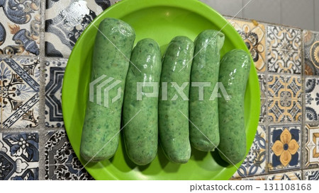 Five green chorizos on a plate indoors at night Five green chorizos on a plate indoors at night 131108168