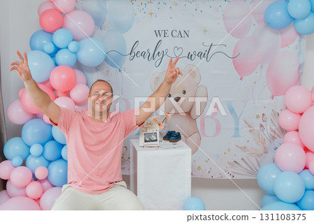 Festive portrait of dad at baby celebration, pastel balloon decor and playful mood. Useful for event planners, lifestyle magazines, family brands and social campaigns 131108375