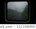 Rainy railway view through a train window with raindrops on glass 131108460