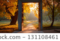 Open wooden doorway framing a sunlit autumn park, golden leaves glowing in morning haze 131108461