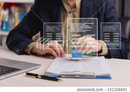 businessman stamping an approved document with a digital signature while reviewing legal documents on a laptop, representing modern document approval processes and e-signatures. businessman stamping an approved document with a digital signature while reviewing legal documents on a laptop, representing modern document approval processes and e-signatures. 131108883