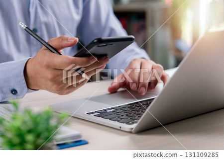business professional planning and managing tasks with a laptop and smartphone, symbolizing teamwork, entrepreneurship, and business growth. business professional planning and managing tasks with a laptop and smartphone, symbolizing teamwork, entrepreneurship, and business growth. 131109285