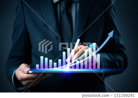 businessman using a tablet to analyze financial marketing growth, with a rising bar chart and arrows representing business success and data analysis. 131109291