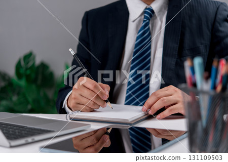 Close-up of manager preparing strategy in office notebook. Great for topics like corporate planning, business work, project development, and productivity. 131109503