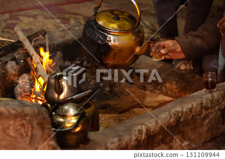 Arab Bedouin hand pouring tea from kettle 131109944