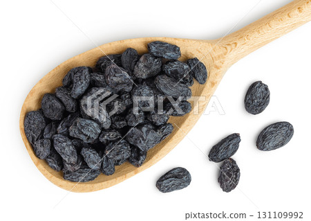 black raisins in wooden spoon isolated on white background. Top view. Flat lay black raisins in wooden spoon isolated on white background. Top view. Flat lay 131109992