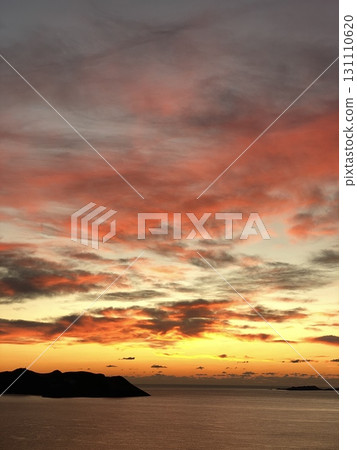 Vibrant sunset sky over ocean with dramatic clouds and silhouettes, ideal for background Vibrant sunset sky over ocean with dramatic clouds and silhouettes, ideal for background 131110620