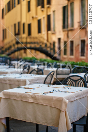 Empty outdoor restaurant tables with cutlery in Venice, Italy Empty outdoor restaurant tables with cutlery in Venice, Italy 131110707