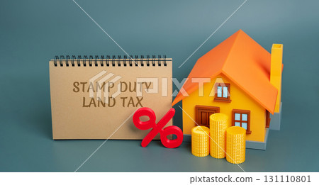 Stamp duty land tax SDLT concept. Taxes assessed during the transfer of real estate between two parties. Buying housing and land. Notes, miniature house and percentage sign with stacks coins Stamp duty land tax SDLT concept. Taxes assessed during the transfer of real estate between two parties. Buying housing and land. Notes, miniature house and percentage sign with stacks coins 131110801