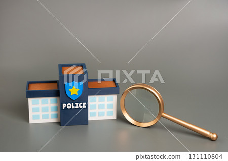 Police building with magnifying glass. Concept of investigation, law enforcement scrutiny, public safety, transparency, crime analysis, and accountability in the justice system. 131110804