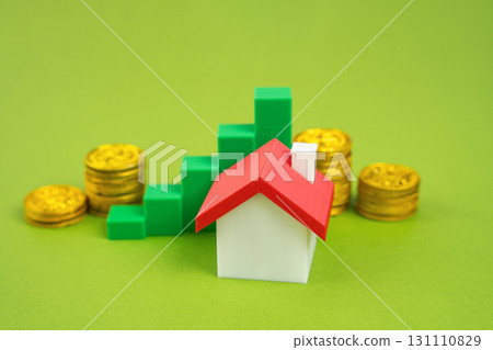 House with gold coins and green graph pointing up. Rising property value. Increasing profitability of housing investments. Real Estate, Investing and Mortgage Rates 131110829