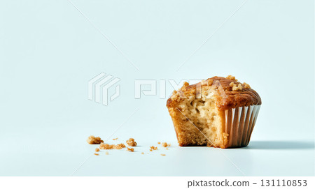 Half-eaten muffin with crumbs on light blue background in minimal food composition 131110853