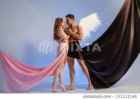 Romantic couple posing artistically in a studio with fabric drapes 131111148