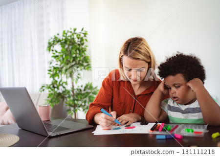 Mother and son coloring with markers on paper at a table Mother and son coloring with markers on paper at a table 131111218