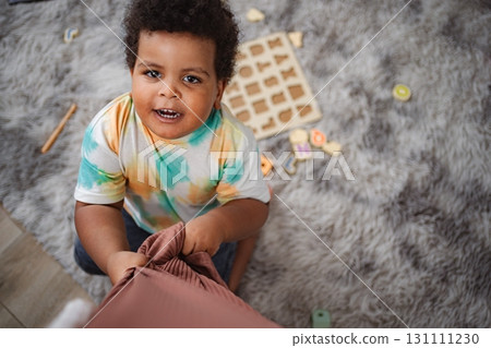 Toddler boy playing alphabet puzzle on fluffy rug 131111230