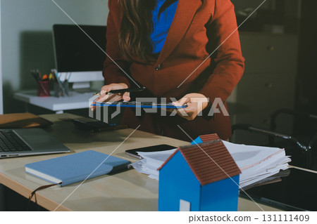 Customer signing a real estate contract in real estate agency. 131111409